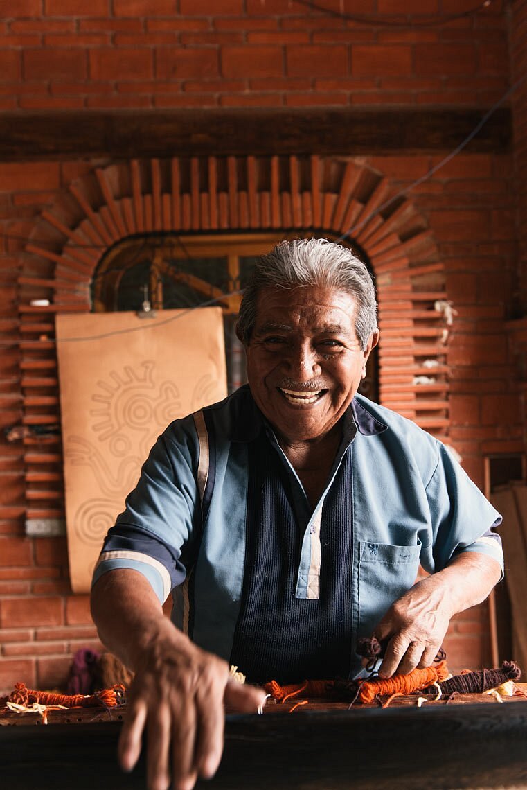 Don Isaac at the loom — three generations of Zapotec technique passed through muscle memory and song.